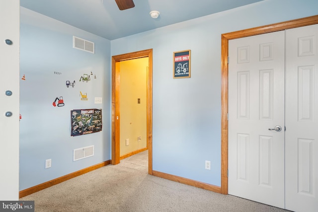 bedroom featuring ceiling fan, light carpet, and a closet