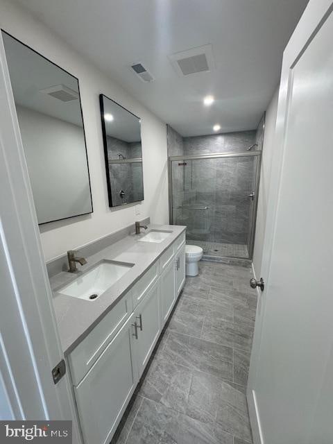 bathroom featuring an enclosed shower, vanity, and toilet