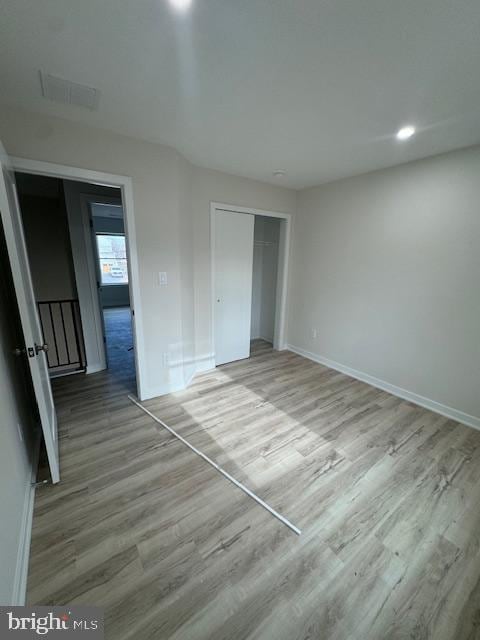 unfurnished bedroom featuring wood-type flooring and a closet