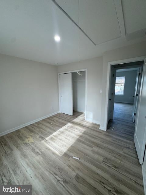 unfurnished bedroom with a closet and wood-type flooring