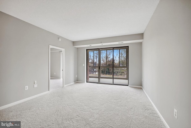 carpeted empty room with a textured ceiling