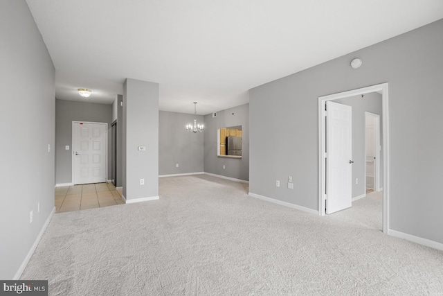 unfurnished room with light carpet and a chandelier