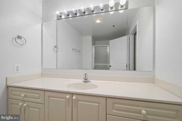 bathroom featuring vanity and a shower with door