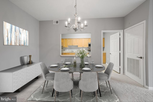 dining room featuring carpet flooring and an inviting chandelier