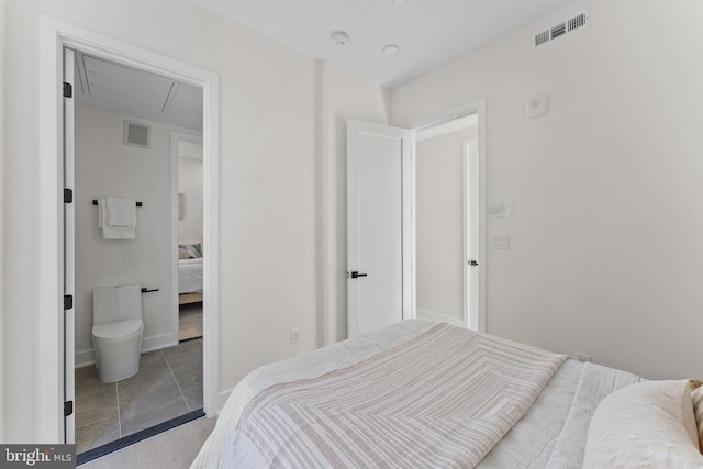 bedroom featuring ensuite bath and light hardwood / wood-style flooring