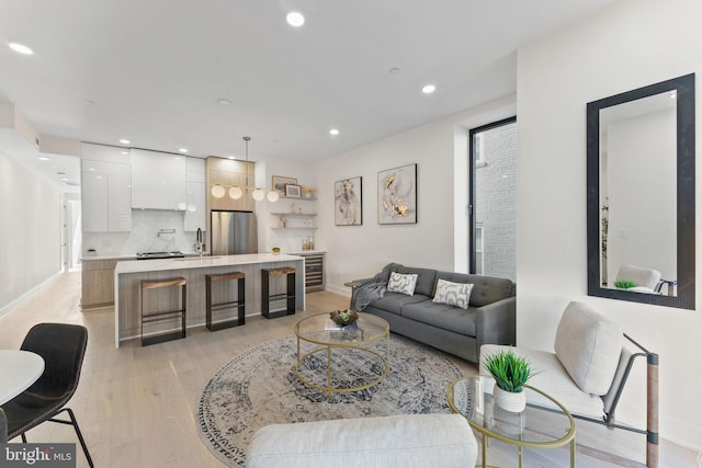 living room with wine cooler, light hardwood / wood-style flooring, and sink