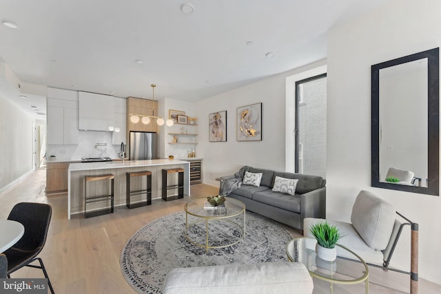 living room with light hardwood / wood-style flooring and sink