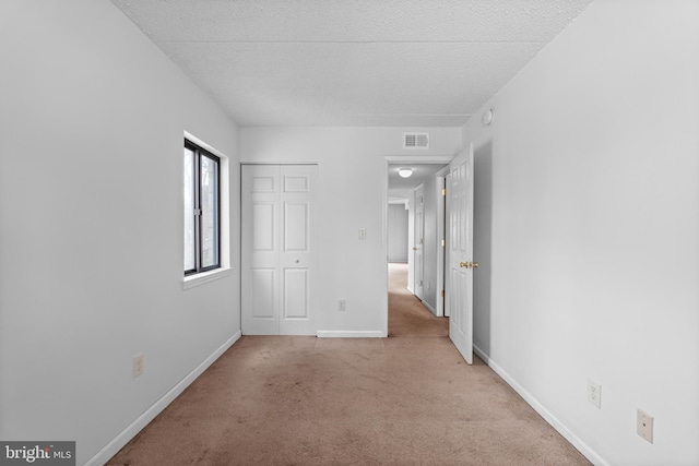 carpeted spare room featuring a textured ceiling