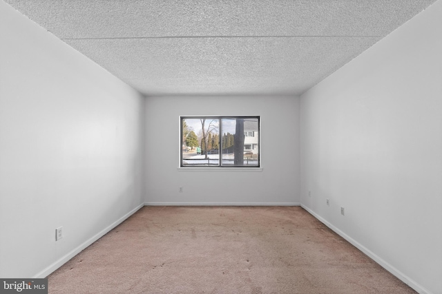 carpeted empty room featuring a textured ceiling