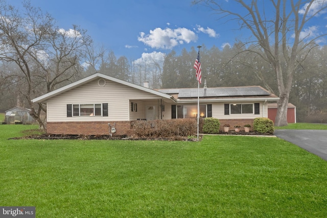 single story home featuring covered porch, a front yard, and solar panels