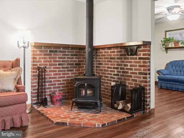 room details featuring hardwood / wood-style floors, ceiling fan, and a wood stove