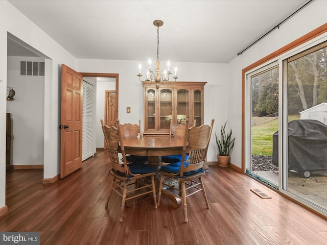 dining space with a notable chandelier and dark hardwood / wood-style floors