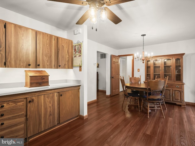 kitchen featuring pendant lighting, dark wood-type flooring, and ceiling fan with notable chandelier