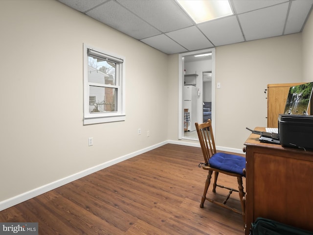 office featuring a paneled ceiling and dark hardwood / wood-style flooring