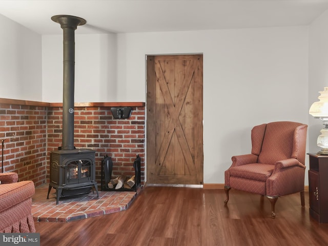 sitting room with wood-type flooring and a wood stove