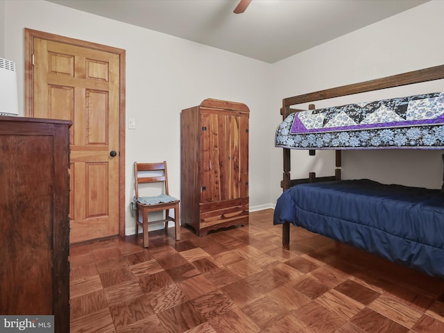 bedroom with ceiling fan and dark parquet floors