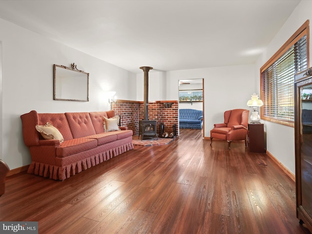 living room with a wood stove and dark wood-type flooring