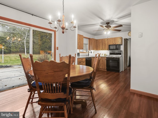 dining area featuring ceiling fan with notable chandelier, dark hardwood / wood-style floors, and sink