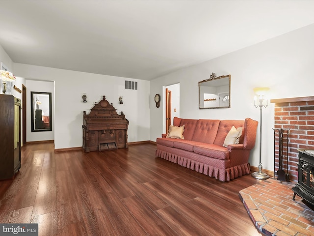 living room with dark hardwood / wood-style floors and a wood stove