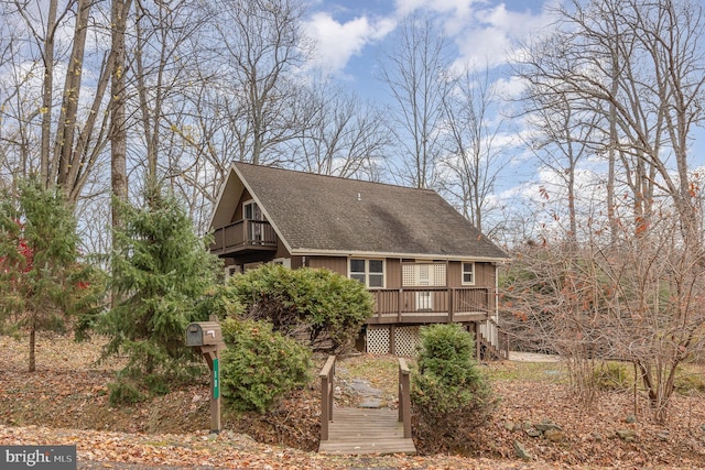 back of property featuring a balcony and a deck