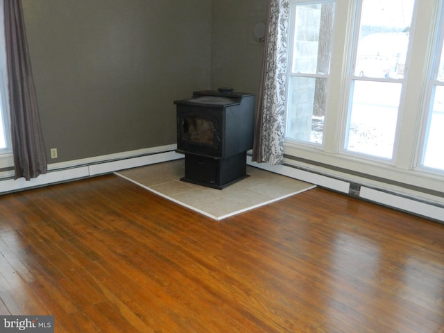 interior details with a wood stove, hardwood / wood-style floors, and a baseboard radiator