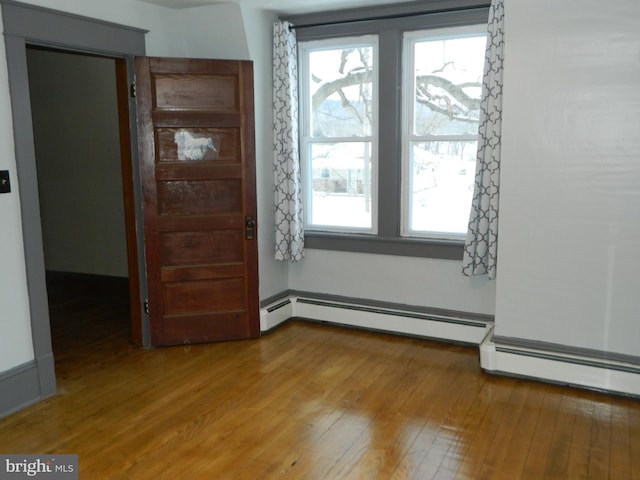 spare room featuring hardwood / wood-style flooring and a baseboard radiator