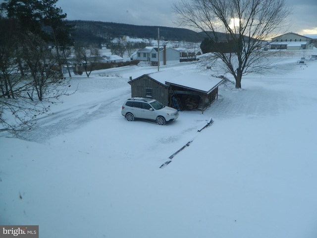 view of snow covered exterior featuring an outbuilding