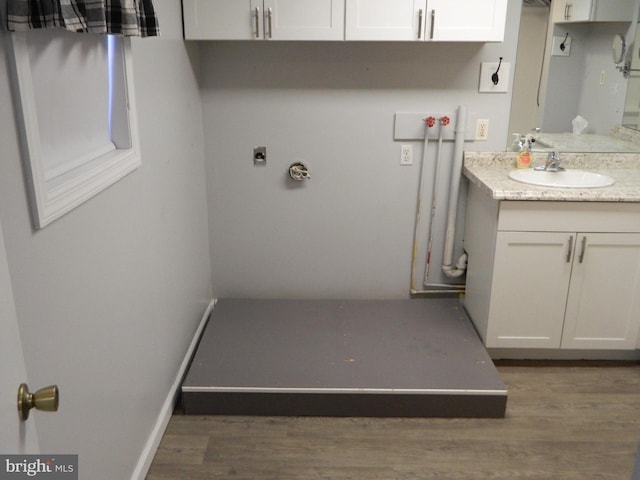 clothes washing area with hookup for a washing machine, sink, dark wood-type flooring, and hookup for an electric dryer