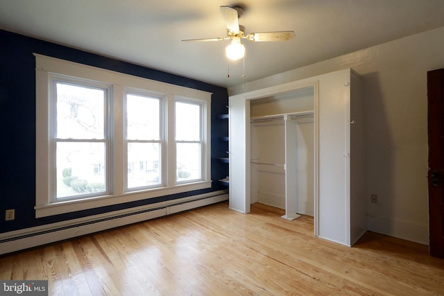 unfurnished bedroom with light wood-type flooring, baseboard heating, and ceiling fan