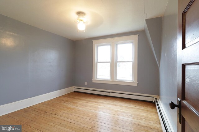 additional living space featuring light hardwood / wood-style floors and a baseboard radiator