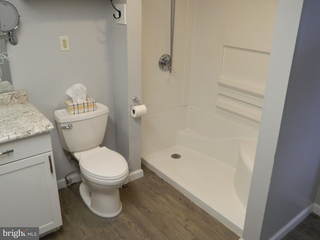 bathroom featuring walk in shower, toilet, vanity, and hardwood / wood-style flooring