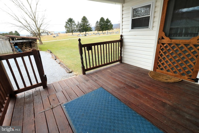 wooden deck featuring a lawn