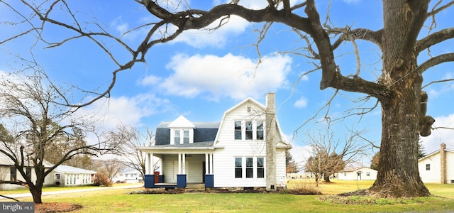 view of property featuring a porch and a front lawn