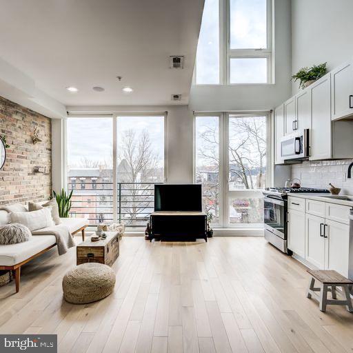 living room with light hardwood / wood-style floors and sink