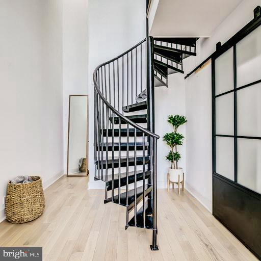 staircase featuring hardwood / wood-style flooring and a barn door