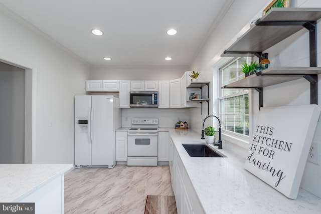 kitchen with light stone countertops, sink, crown molding, white appliances, and white cabinets