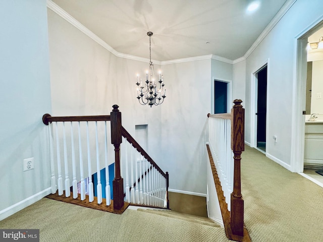 stairs with a chandelier, carpet floors, crown molding, and sink