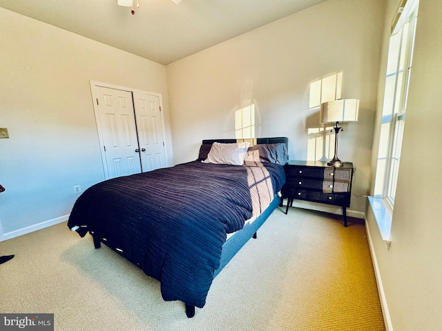 bedroom featuring light carpet, a closet, and multiple windows