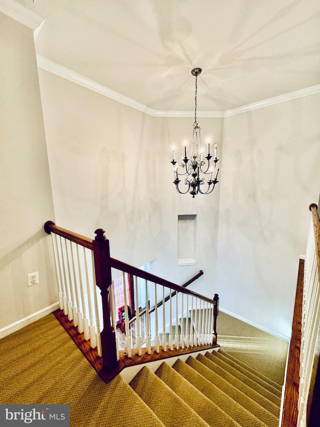 staircase featuring carpet flooring, crown molding, and an inviting chandelier