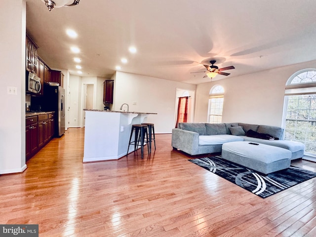 living room with ceiling fan and light hardwood / wood-style floors