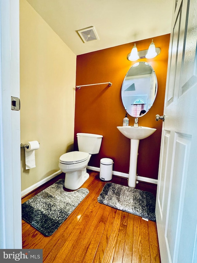 bathroom featuring hardwood / wood-style floors and toilet