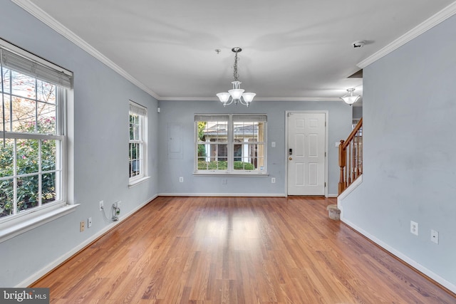 interior space featuring a wealth of natural light, crown molding, a chandelier, and light wood-type flooring