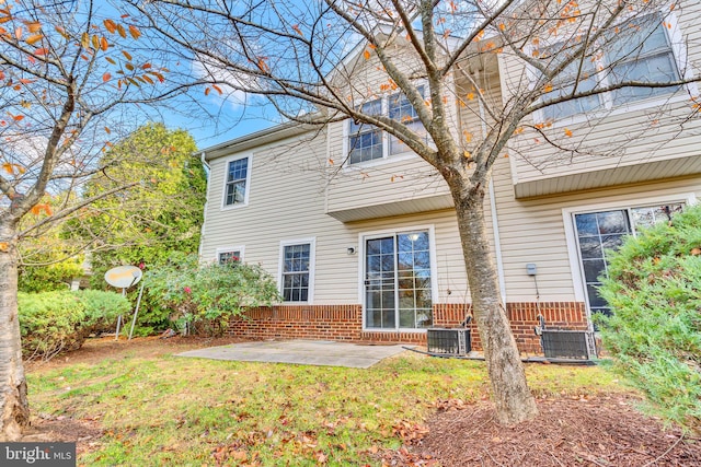 rear view of property featuring a lawn, a patio, and central AC unit