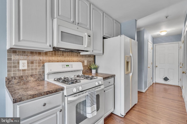 kitchen featuring white cabinets, light wood-type flooring, white appliances, and tasteful backsplash