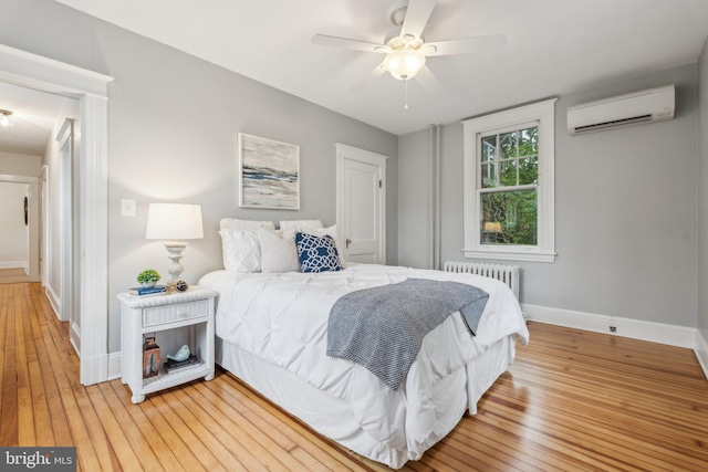 1411 W St, Annapolis, MD 21401 - bedroom featuring a wall mounted air conditioner, radiator, light wood-type flooring, ceiling fan, and baseboards