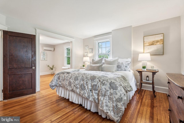 1411 W St, Annapolis, MD 21401 - bedroom featuring a wall mounted AC, baseboards, and hardwood / wood-style floors