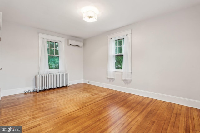 1411 W St, Annapolis, MD 21401 - spare room featuring light wood-style floors, an AC wall unit, baseboards, and radiator heating unit