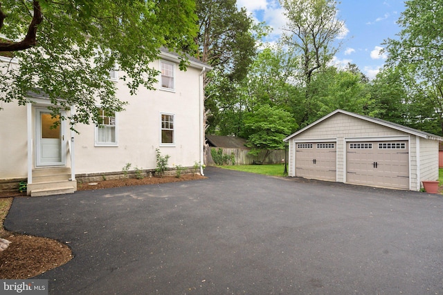 1411 W St, Annapolis, MD 21401 - view of side of property featuring a detached garage, entry steps, an outbuilding, and fence