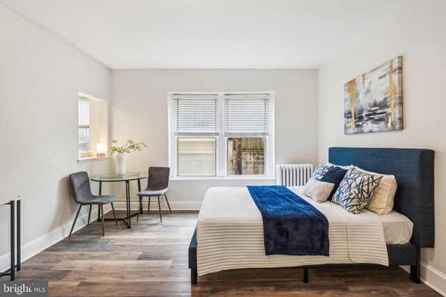 bedroom with hardwood / wood-style floors and radiator heating unit