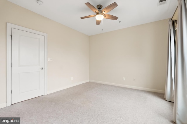 spare room with light colored carpet and ceiling fan